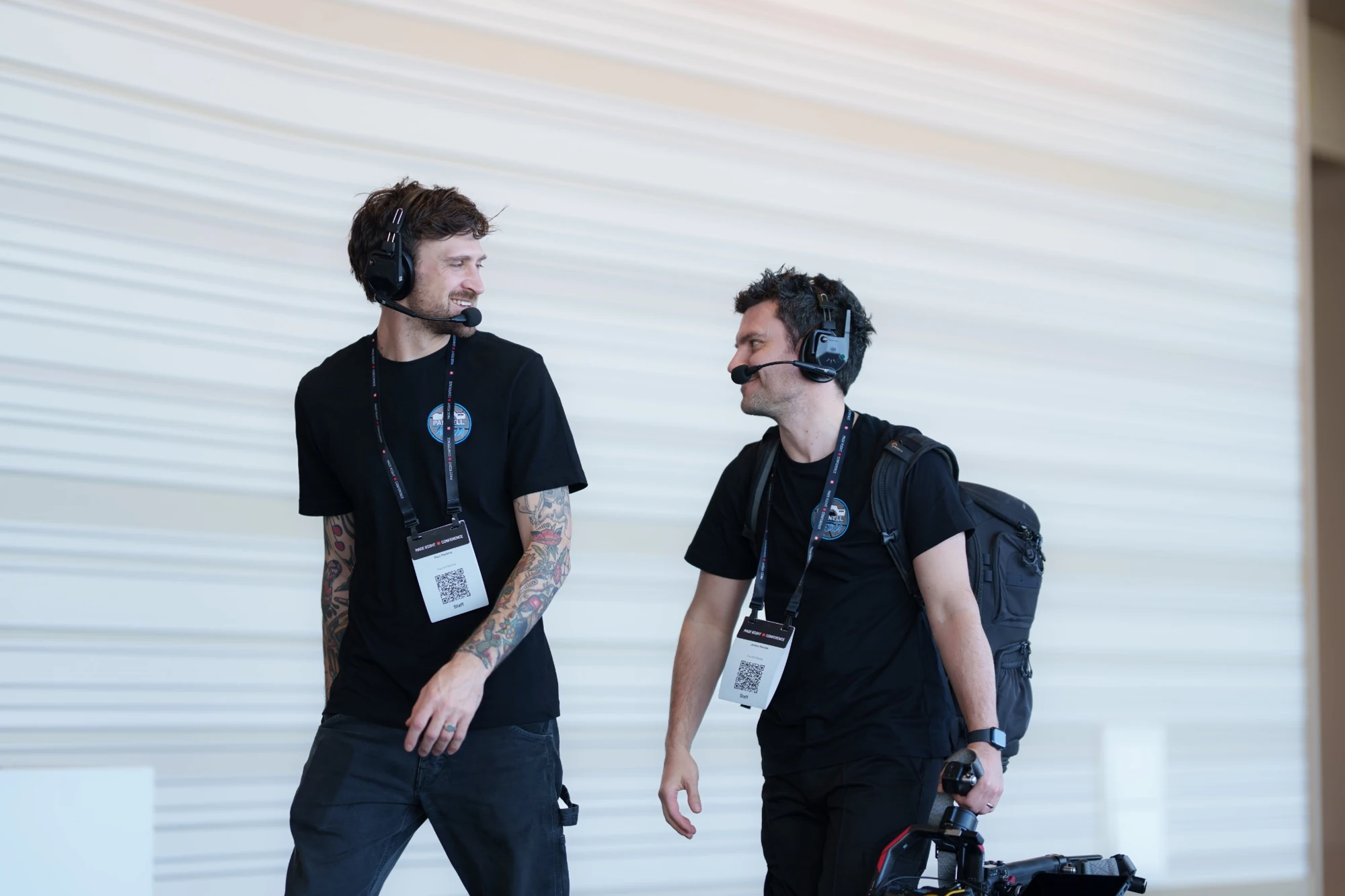 Two crew members talking between takes, wearing production headsets